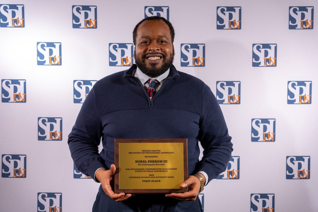 Horsemen Sports Media Founder and Editor-In-Chief Noral Parham holding an award for first place in coverage of race and diversity issues in 2024.